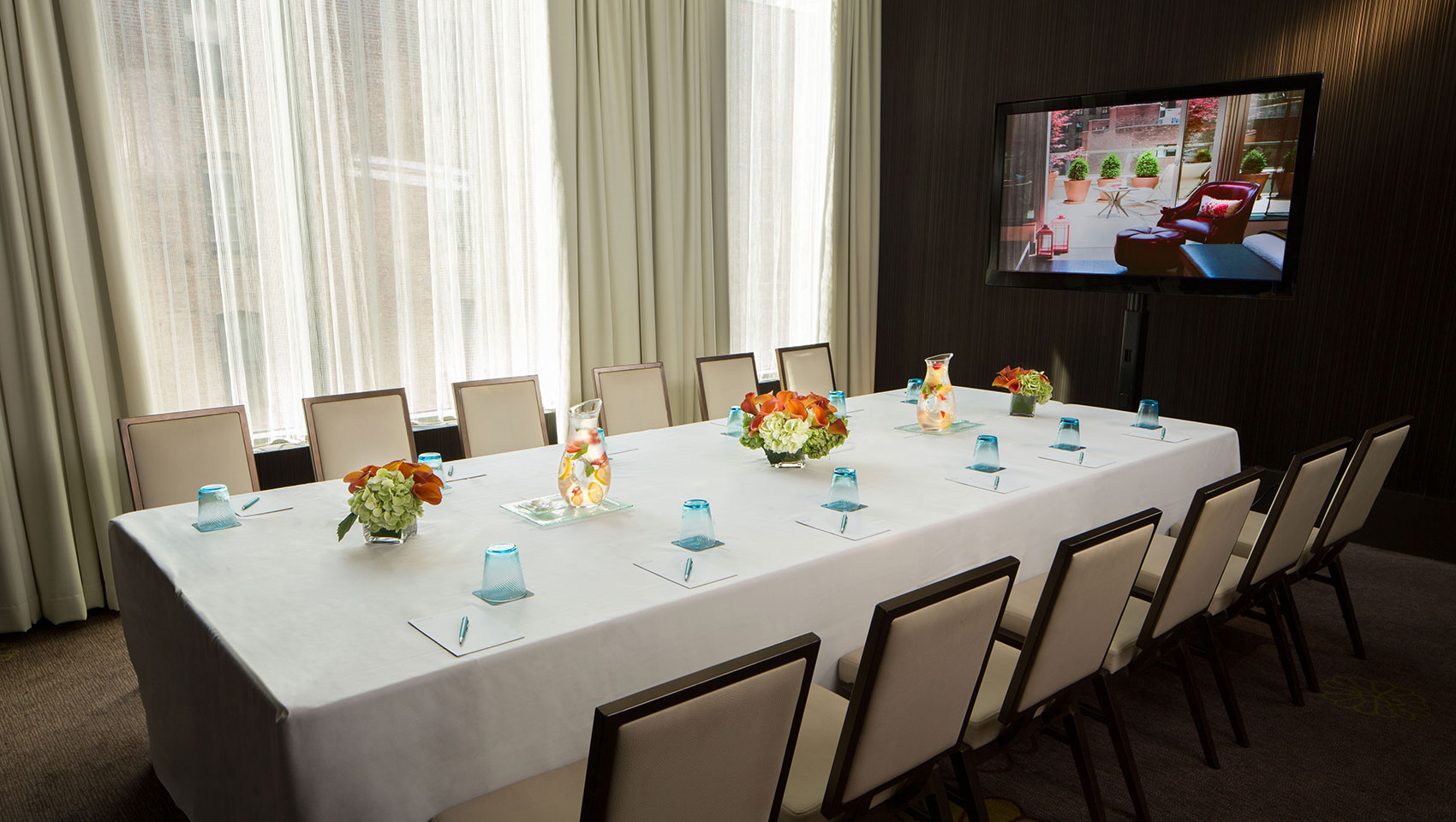 Invent II meeting space with group meeting table with notepads next to a large screen