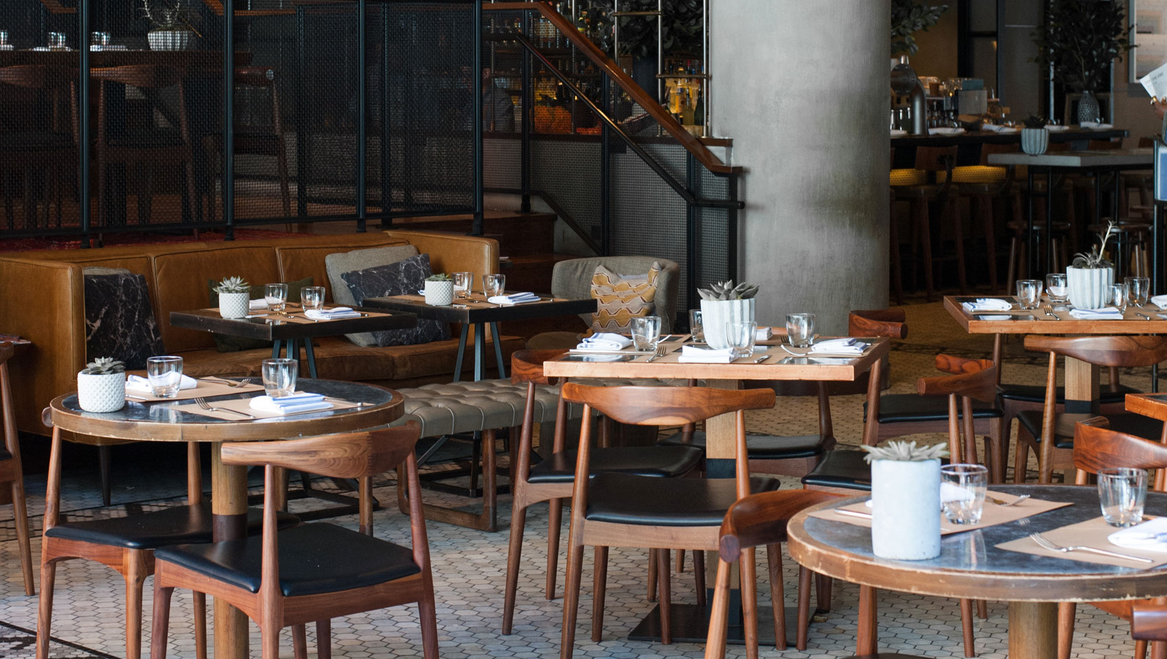 The Vine tabletop seating with place settings and plants on top of tables