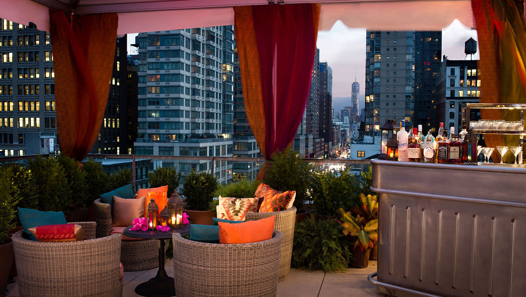 Kimpton Hotel Eventi outdoor event area with seating and bar overlooking street with surrounding skyscrapers