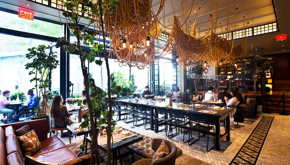 The Vine restaurant seating under knotted art piece fixture with guests at tables