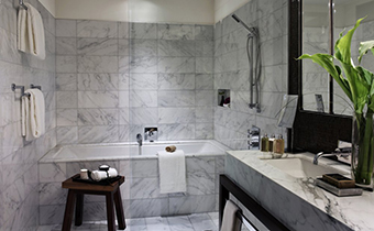 Kimpton Hotel Eventi Premier One Bedroom Suite living area with seating, coffee table, and mounted television
