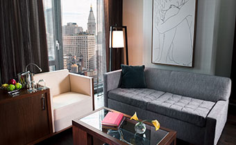 Kimpton Hotel Eventi Executive one bedroom suite living area with seating next to windows overlooking city views