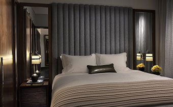 King deluxe guestroom bed with 2 adjacent nightstands and accent pillow